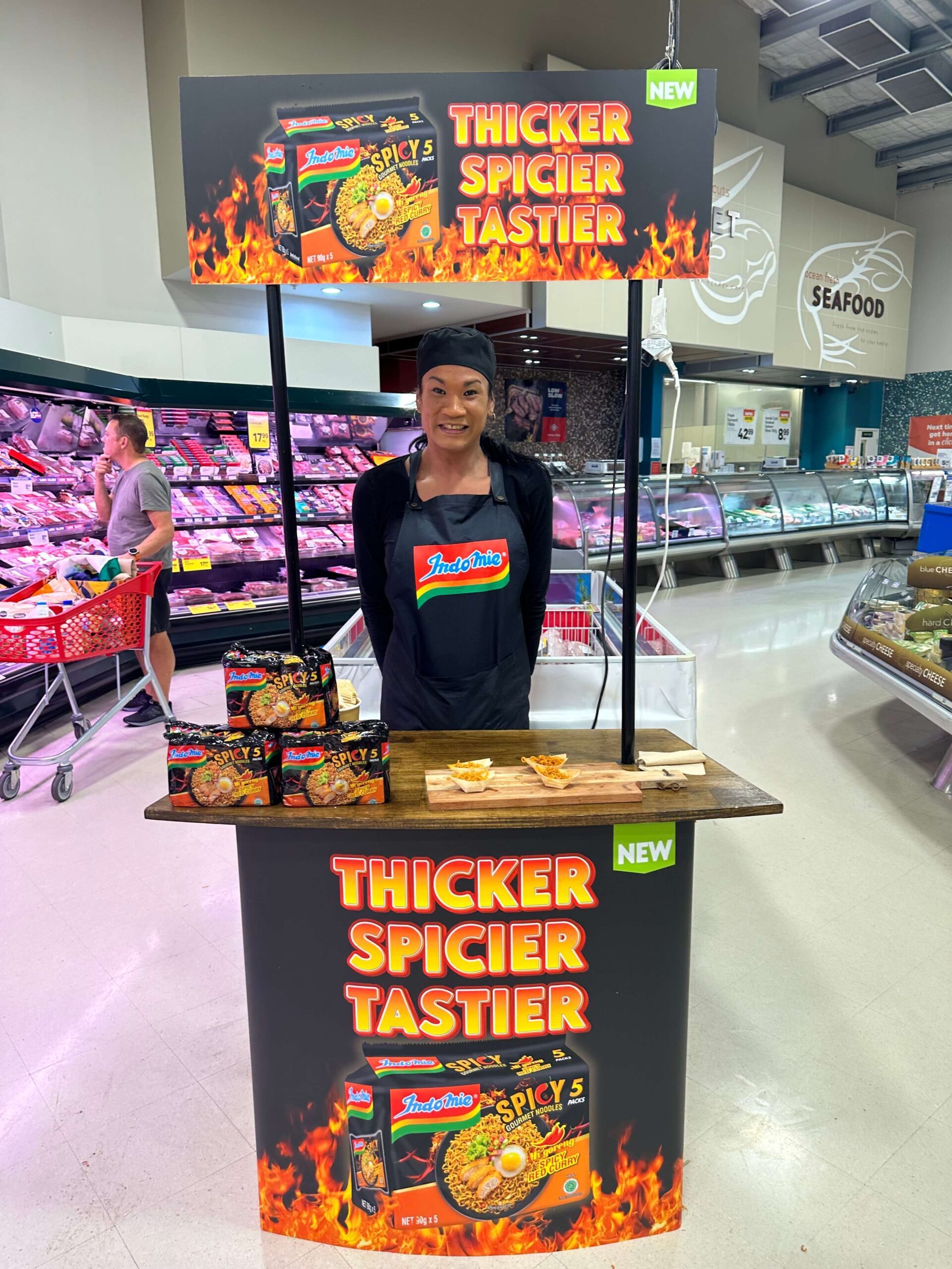 Brand Ambassador at indomie stall offering samples of a hot spicy noodle